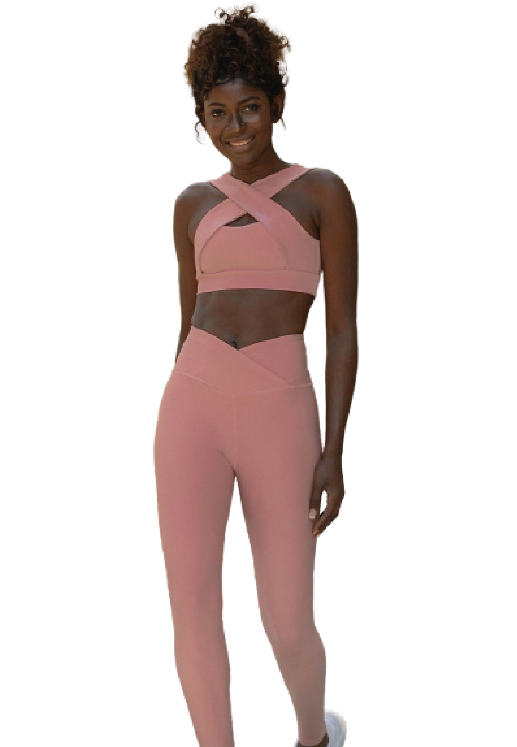 Person in einem rosa Criss-Cross-Sport-BH von Lismina und 1099 Ve Waist Leggings in Rose, lächelt vor einem weißen Hintergrund.